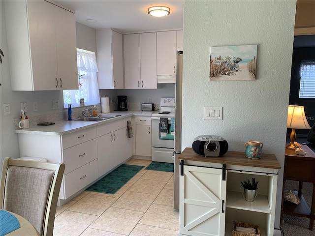 18094 Ackerman Ave, Port Charlotte, FL 33948 - kitchen with white electric stove, light countertops, under cabinet range hood, a textured wall, and white cabinetry