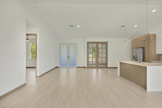 4530 Boston Ter, North Port, FL 34288 - unfurnished living room featuring french doors, lofted ceiling, recessed lighting, and light wood-type flooring