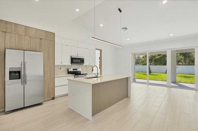 4530 Boston Ter, North Port, FL 34288 - kitchen with stainless steel appliances, decorative backsplash, light countertops, lofted ceiling, and an island with sink