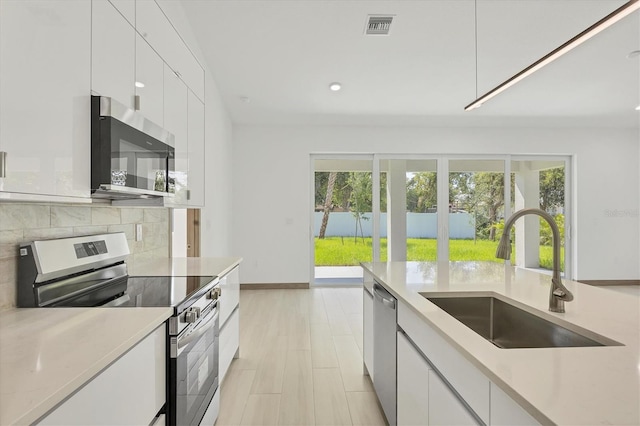 4530 Boston Ter, North Port, FL 34288 - kitchen featuring stainless steel appliances, white cabinetry, backsplash, modern cabinets, and recessed lighting