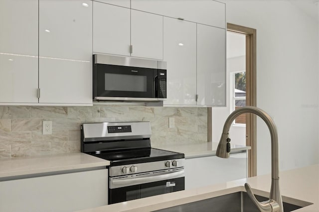 4530 Boston Ter, North Port, FL 34288 - kitchen featuring stainless steel appliances, white cabinets, light countertops, backsplash, and modern cabinets