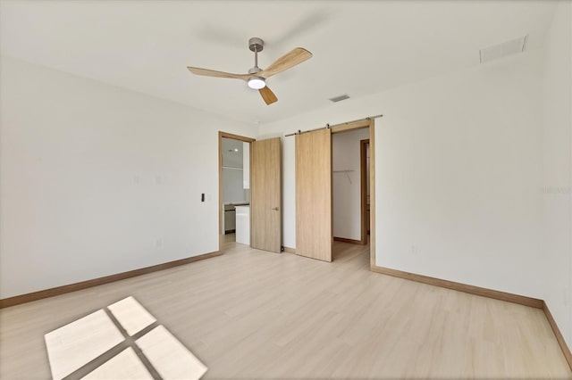 4530 Boston Ter, North Port, FL 34288 - unfurnished bedroom featuring a spacious closet, light wood-style flooring, ceiling fan, and a barn door