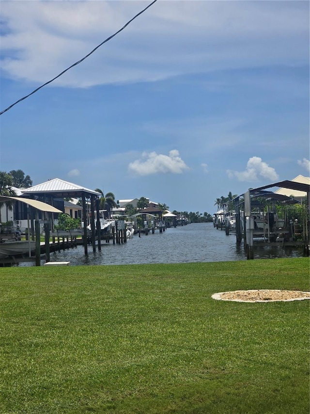 24317 Treasure Island Blvd, Punta Gorda, FL 33955 - dock area with boat lift, a lawn, and a water view