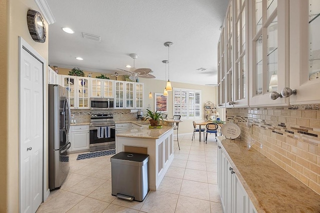 3385 Via Montana Way N, Fort Myers, FL 33917 - kitchen featuring stainless steel appliances, decorative backsplash, light tile patterned floors, light stone counters, and decorative light fixtures