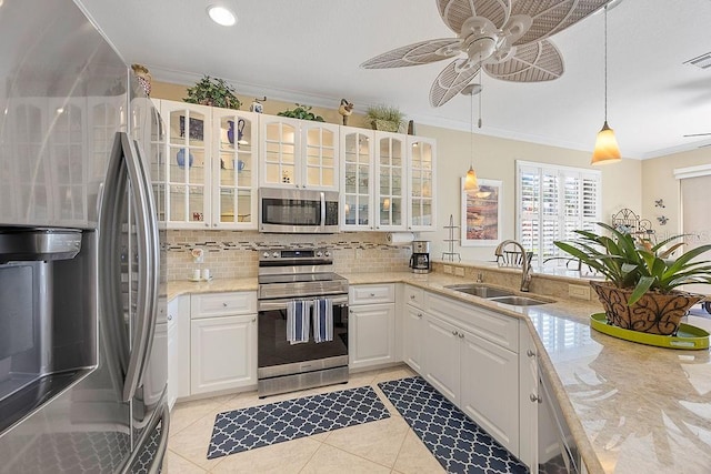 3385 Via Montana Way N, Fort Myers, FL 33917 - kitchen featuring stainless steel appliances, ornamental molding, tasteful backsplash, a ceiling fan, and white cabinetry