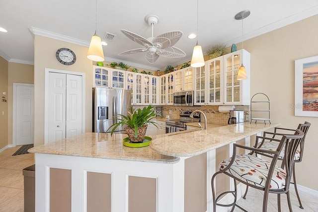 3385 Via Montana Way N, Fort Myers, FL 33917 - kitchen with stainless steel appliances, crown molding, a peninsula, light stone countertops, and a ceiling fan