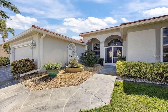3385 Via Montana Way N, Fort Myers, FL 33917 - property entrance with a garage, stucco siding, and a tile roof