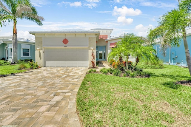 10478 Coquina Ct, Placida, FL 33946 - view of front of house featuring decorative driveway, an attached garage, a front yard, and stucco siding