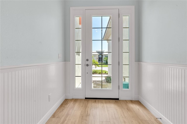 10478 Coquina Ct, Placida, FL 33946 - entryway with light wood-style flooring, a wainscoted wall, and plenty of natural light
