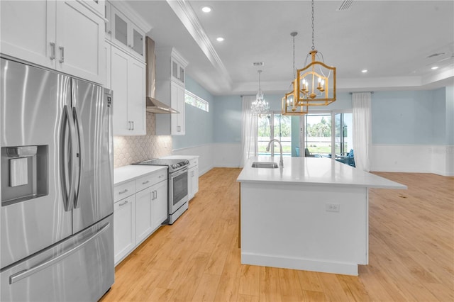 10478 Coquina Ct, Placida, FL 33946 - kitchen with appliances with stainless steel finishes, a tray ceiling, a chandelier, a center island with sink, and light countertops