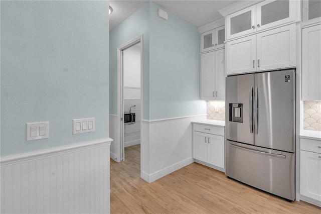 10478 Coquina Ct, Placida, FL 33946 - kitchen with stainless steel refrigerator with ice dispenser, wainscoting, light countertops, light wood-style floors, and white cabinetry
