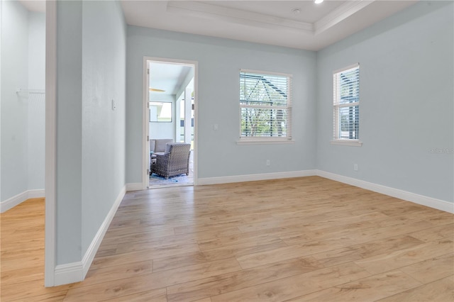 10478 Coquina Ct, Placida, FL 33946 - spare room with light wood finished floors, a tray ceiling, and crown molding