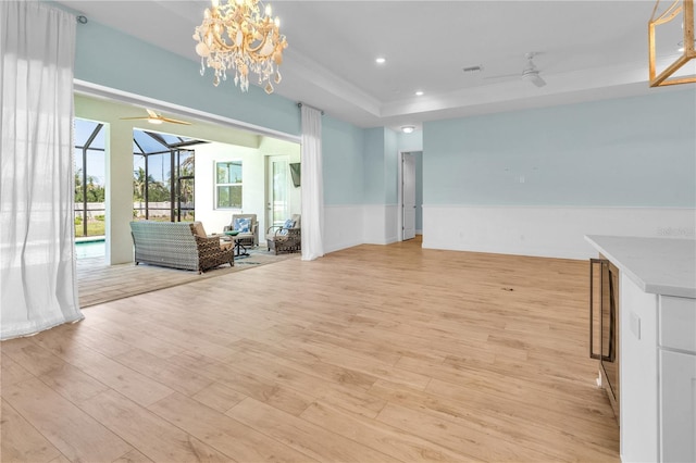 10478 Coquina Ct, Placida, FL 33946 - unfurnished room featuring ceiling fan, a wainscoted wall, crown molding, light wood-type flooring, and a raised ceiling