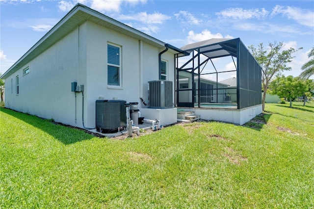 10478 Coquina Ct, Placida, FL 33946 - rear view of house featuring a lawn, stucco siding, and glass enclosure