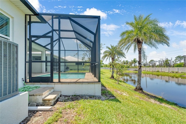 10478 Coquina Ct, Placida, FL 33946 - view of green lawn with glass enclosure, a water view, and a patio area