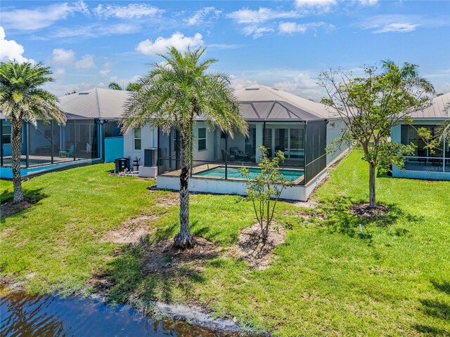 10478 Coquina Ct, Placida, FL 33946 - back of property featuring an outdoor pool, a lawn, glass enclosure, and a metal roof