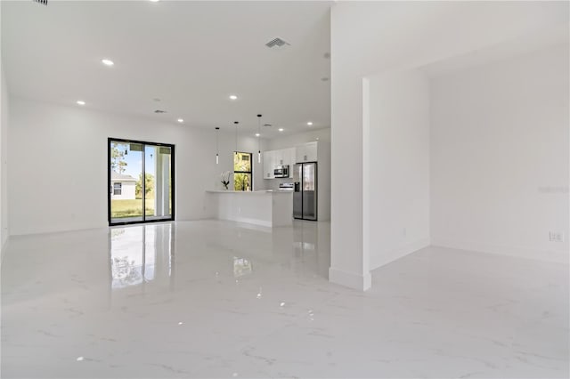 2911 37th St W, Lehigh Acres, FL 33971 - unfurnished living room featuring light marble finish flooring and recessed lighting