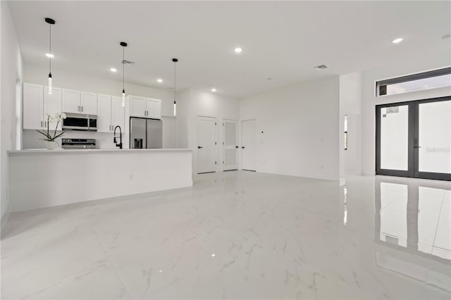 2911 37th St W, Lehigh Acres, FL 33971 - unfurnished living room with recessed lighting, light marble finish floors, and french doors