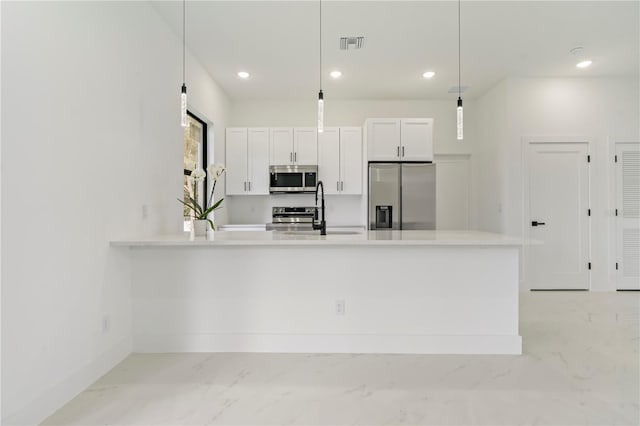 2911 37th St W, Lehigh Acres, FL 33971 - kitchen with appliances with stainless steel finishes, light marble finish flooring, white cabinetry, light countertops, and decorative light fixtures