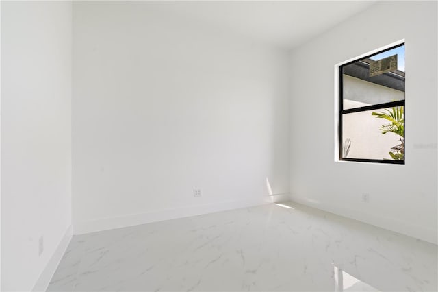 2911 37th St W, Lehigh Acres, FL 33971 - empty room featuring marble look tile flooring and baseboards