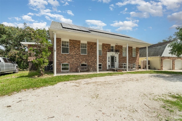 6605 NE Masters Ave, Arcadia, FL 34266 - back of house featuring roof mounted solar panels, brick siding, and covered porch