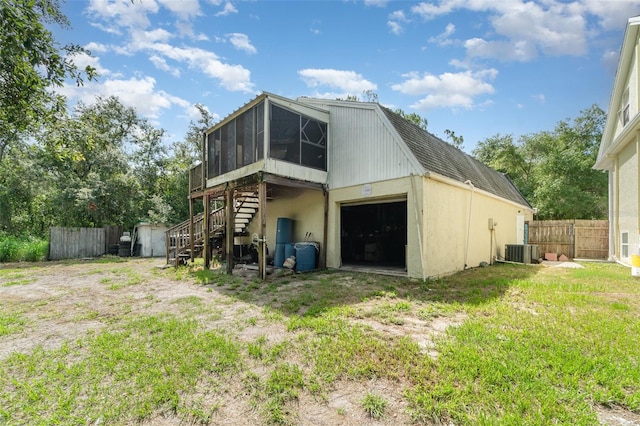 6605 NE Masters Ave, Arcadia, FL 34266 - back of property featuring a sunroom, stairs, a storage unit, and a detached garage
