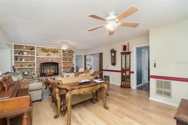6605 NE Masters Ave, Arcadia, FL 34266 - living area featuring a ceiling fan, light wood finished floors, a fireplace, and built in shelves
