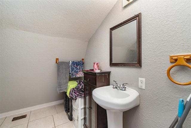 6605 NE Masters Ave, Arcadia, FL 34266 - bathroom featuring vaulted ceiling, tile patterned flooring, and a textured ceiling