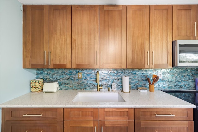 1027 Coral Ridge Dr, Punta Gorda, FL 33950 - kitchen with stainless steel microwave, backsplash, and brown cabinets