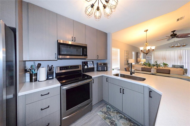 1115 San Cristobal Ave, Punta Gorda, FL 33983 - kitchen with stainless steel appliances, gray cabinets, a chandelier, light wood finished floors, and plenty of natural light