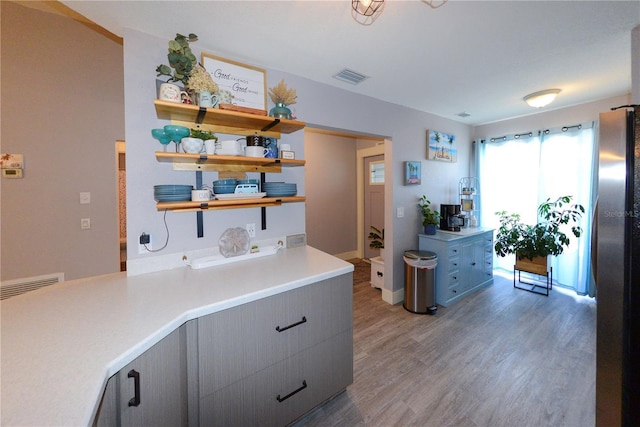 1115 San Cristobal Ave, Punta Gorda, FL 33983 - kitchen featuring open shelves, wood finished floors, gray cabinetry, and light countertops