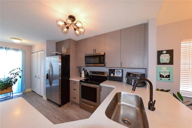 1115 San Cristobal Ave, Punta Gorda, FL 33983 - kitchen with stainless steel appliances, light wood finished floors, light countertops, and a chandelier