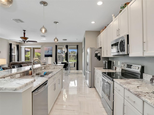 4180 Lenox Blvd, Venice, FL 34293 - kitchen with stainless steel appliances, light marble finish floors, open floor plan, recessed lighting, and an island with sink
