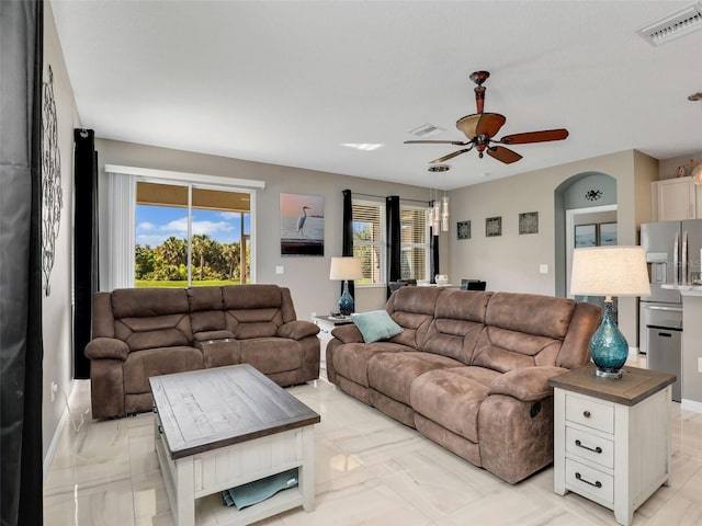 4180 Lenox Blvd, Venice, FL 34293 - living area featuring light marble finish flooring, a ceiling fan, and arched walkways