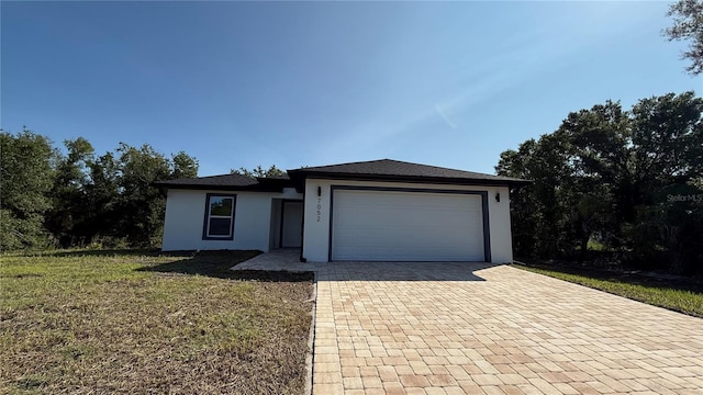 7052 Legion St, Port Charlotte, FL 33981 - view of front of home featuring stucco siding, decorative driveway, an attached garage, and a front yard