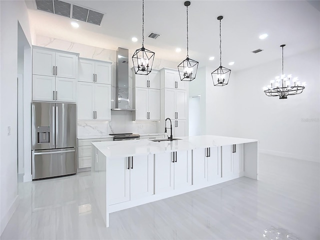 576 Mcdill Dr, Port Charlotte, FL 33953 - kitchen with appliances with stainless steel finishes, wall chimney range hood, a kitchen island with sink, light countertops, and hanging light fixtures