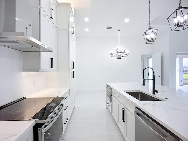 576 Mcdill Dr, Port Charlotte, FL 33953 - kitchen with stainless steel appliances, wall chimney exhaust hood, a chandelier, light stone counters, and recessed lighting