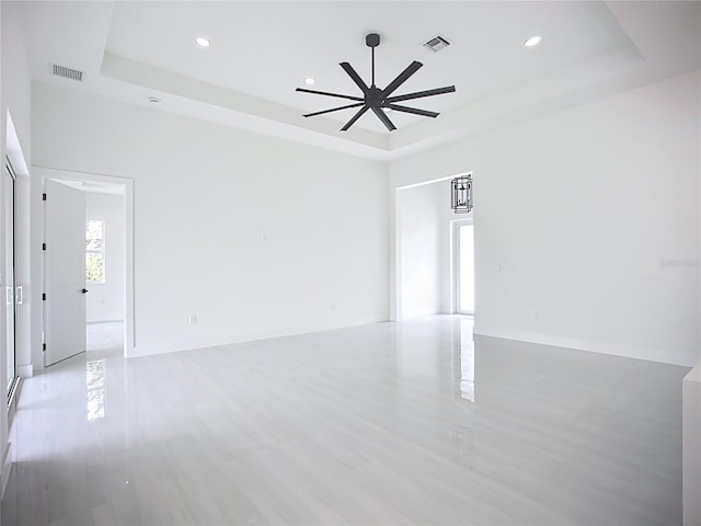 576 Mcdill Dr, Port Charlotte, FL 33953 - unfurnished room featuring a tray ceiling, ceiling fan, recessed lighting, and light wood-style floors