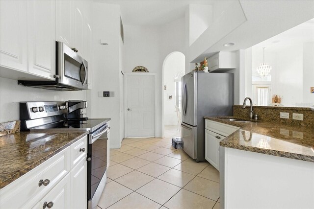 2329 Como St, Port Charlotte, FL 33948 - kitchen featuring stainless steel appliances, white cabinets, dark stone counters, a chandelier, and light tile patterned floors