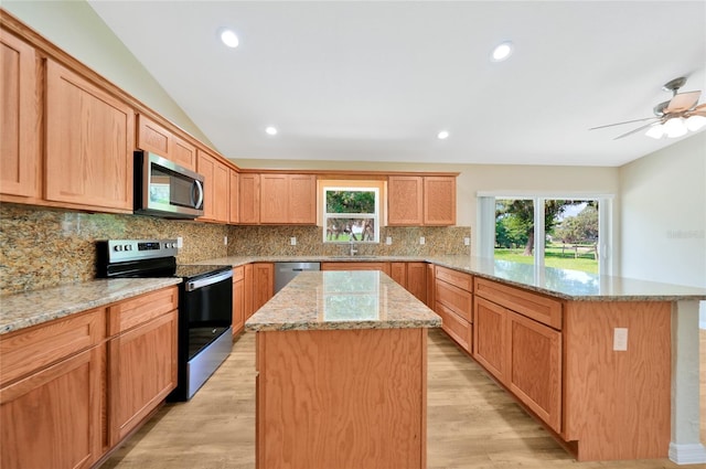 3993 NE Bobay Rd, Arcadia, FL 34266 - kitchen with appliances with stainless steel finishes, a peninsula, a kitchen island, light wood-style flooring, and backsplash