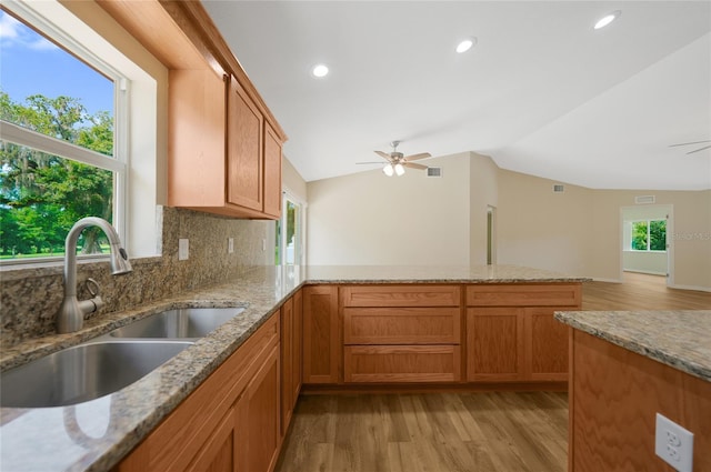 3993 NE Bobay Rd, Arcadia, FL 34266 - kitchen with ceiling fan, a peninsula, vaulted ceiling, light wood-style floors, and backsplash