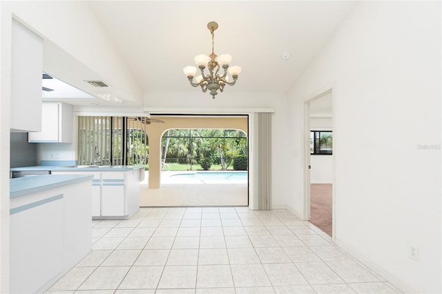 18147 Brazil Ave, Port Charlotte, FL 33948 - kitchen with a chandelier, light countertops, white cabinets, and hanging light fixtures