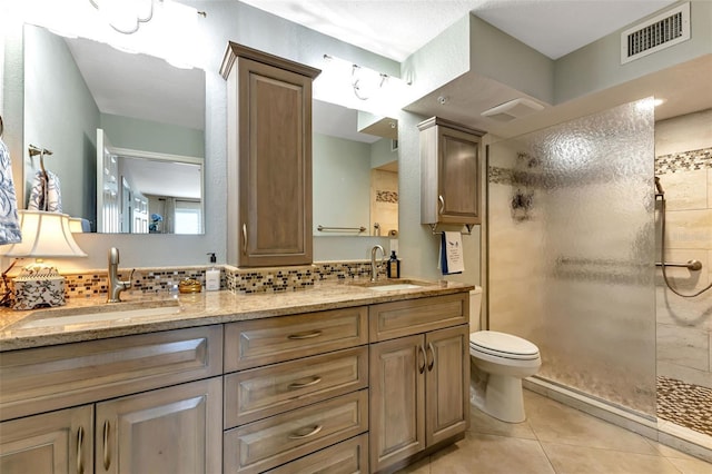 1250 W Marion Ave Unit 333, Punta Gorda, FL 33950 - bathroom featuring a tile shower, double vanity, tasteful backsplash, and tile patterned floors
