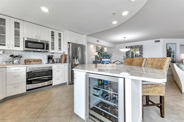 1250 W Marion Ave Unit 333, Punta Gorda, FL 33950 - kitchen with stainless steel appliances, a breakfast bar, white cabinets, and recessed lighting