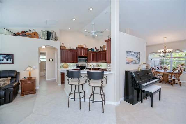 3824 Dominic St, North Port, FL 34288 - kitchen featuring stainless steel appliances, a breakfast bar area, ceiling fan, a chandelier, and light countertops