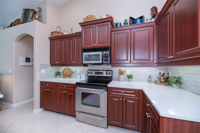 3824 Dominic St, North Port, FL 34288 - kitchen with appliances with stainless steel finishes, reddish brown cabinets, light countertops, backsplash, and light tile patterned flooring