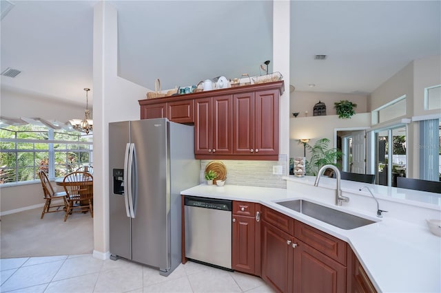 3824 Dominic St, North Port, FL 34288 - kitchen with stainless steel appliances, a chandelier, light countertops, reddish brown cabinets, and light tile patterned floors