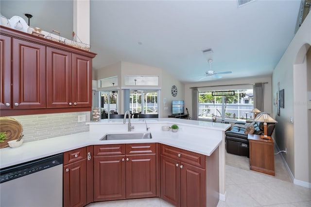 3824 Dominic St, North Port, FL 34288 - kitchen with stainless steel dishwasher, reddish brown cabinets, a peninsula, open floor plan, and vaulted ceiling