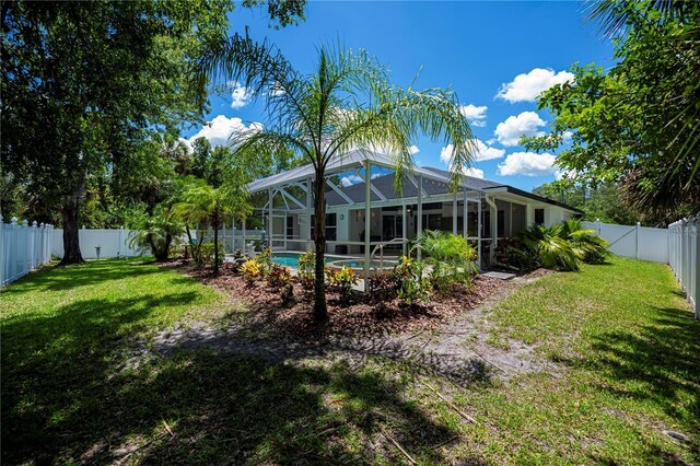 3824 Dominic St, North Port, FL 34288 - rear view of house with a fenced backyard and glass enclosure