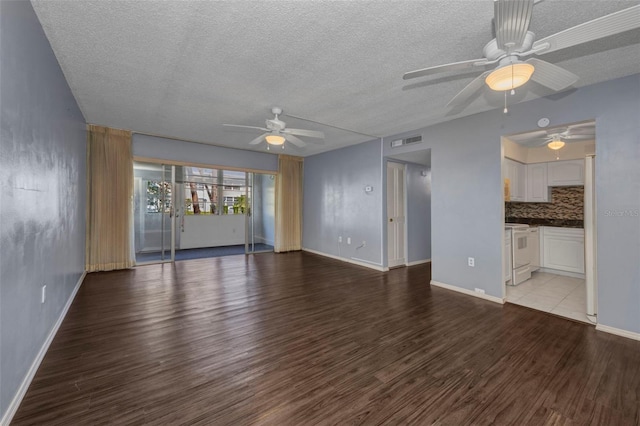 2437 Harbor Blvd Unit 114, Port Charlotte, FL 33952 - unfurnished living room featuring a ceiling fan, a textured ceiling, and wood finished floors